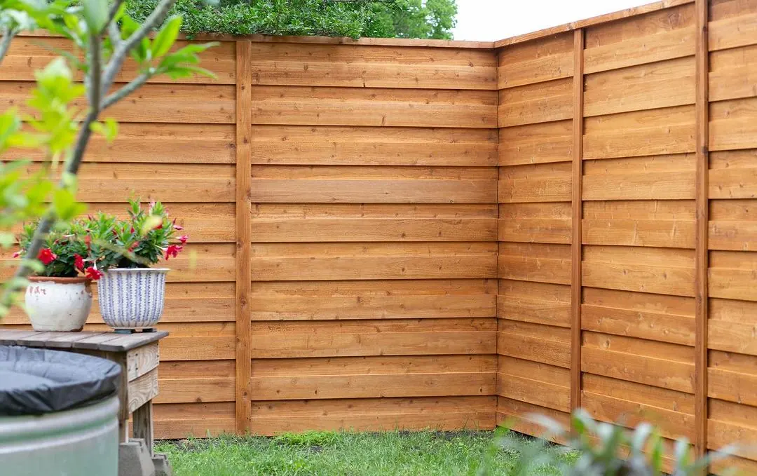 Horizontal cedar privacy fence in a backyard corner