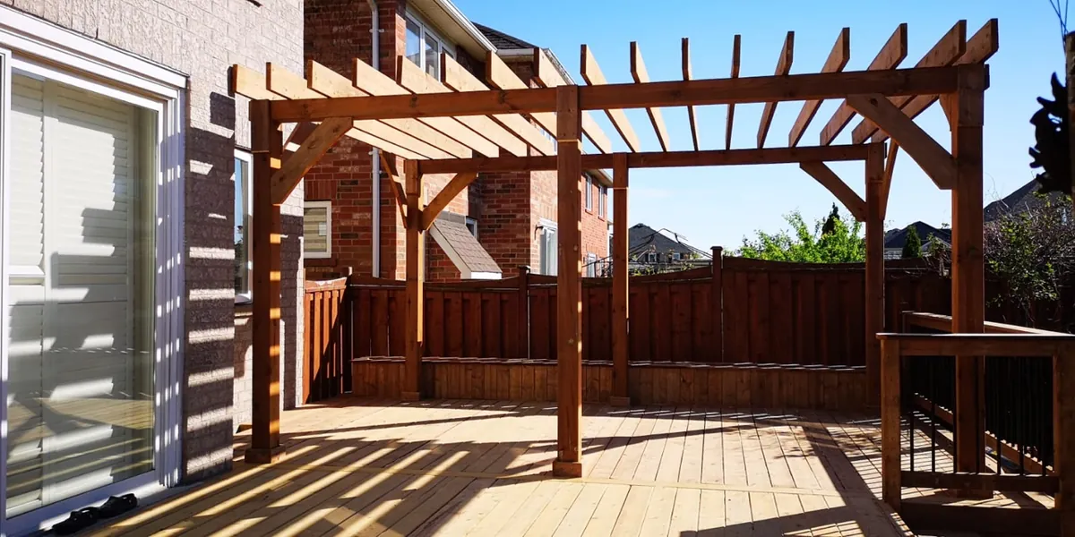 Northern Deck cedar pergola built over a deck in a suburban backyard